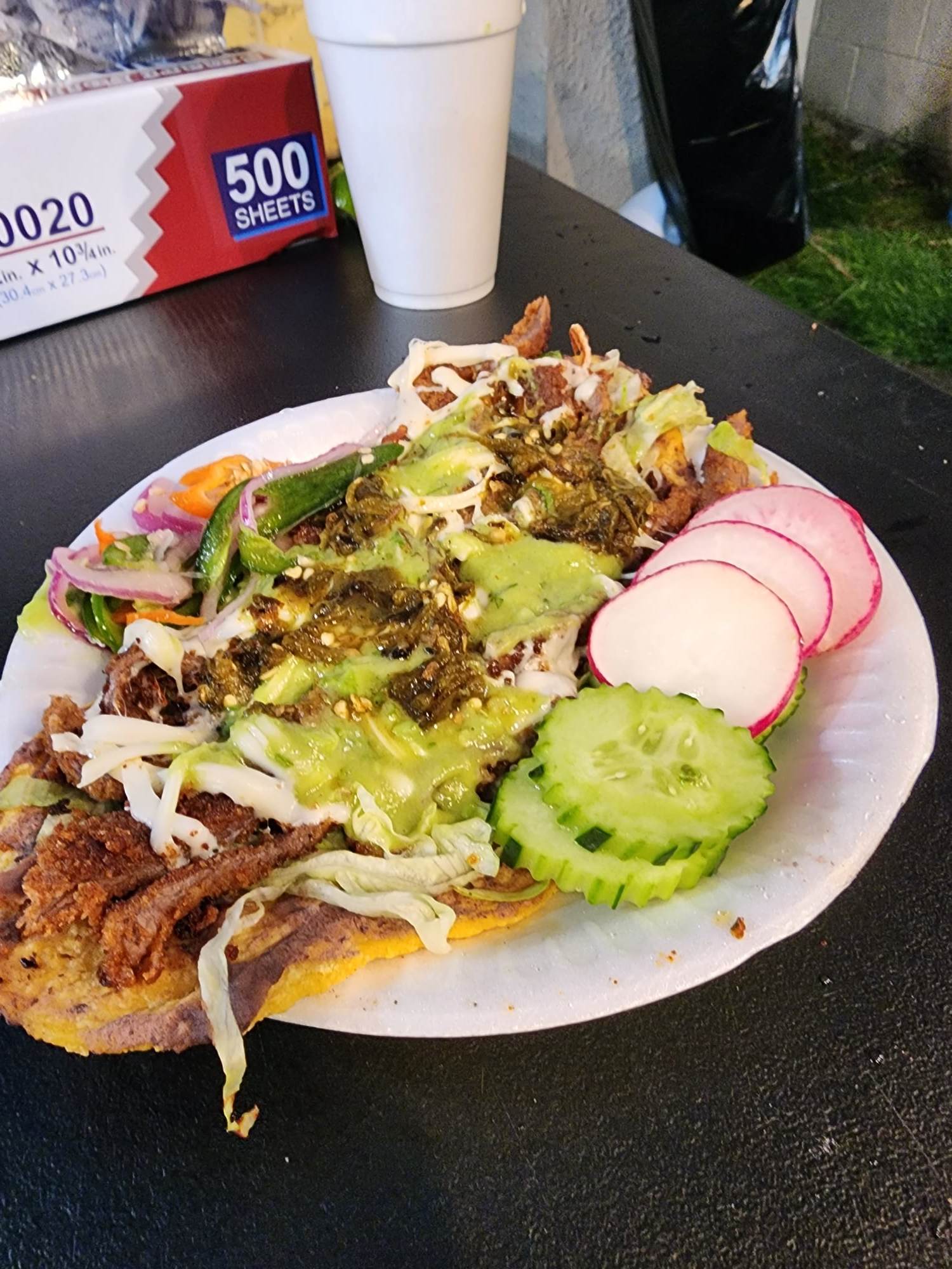 Huarache topped with meat and veggies